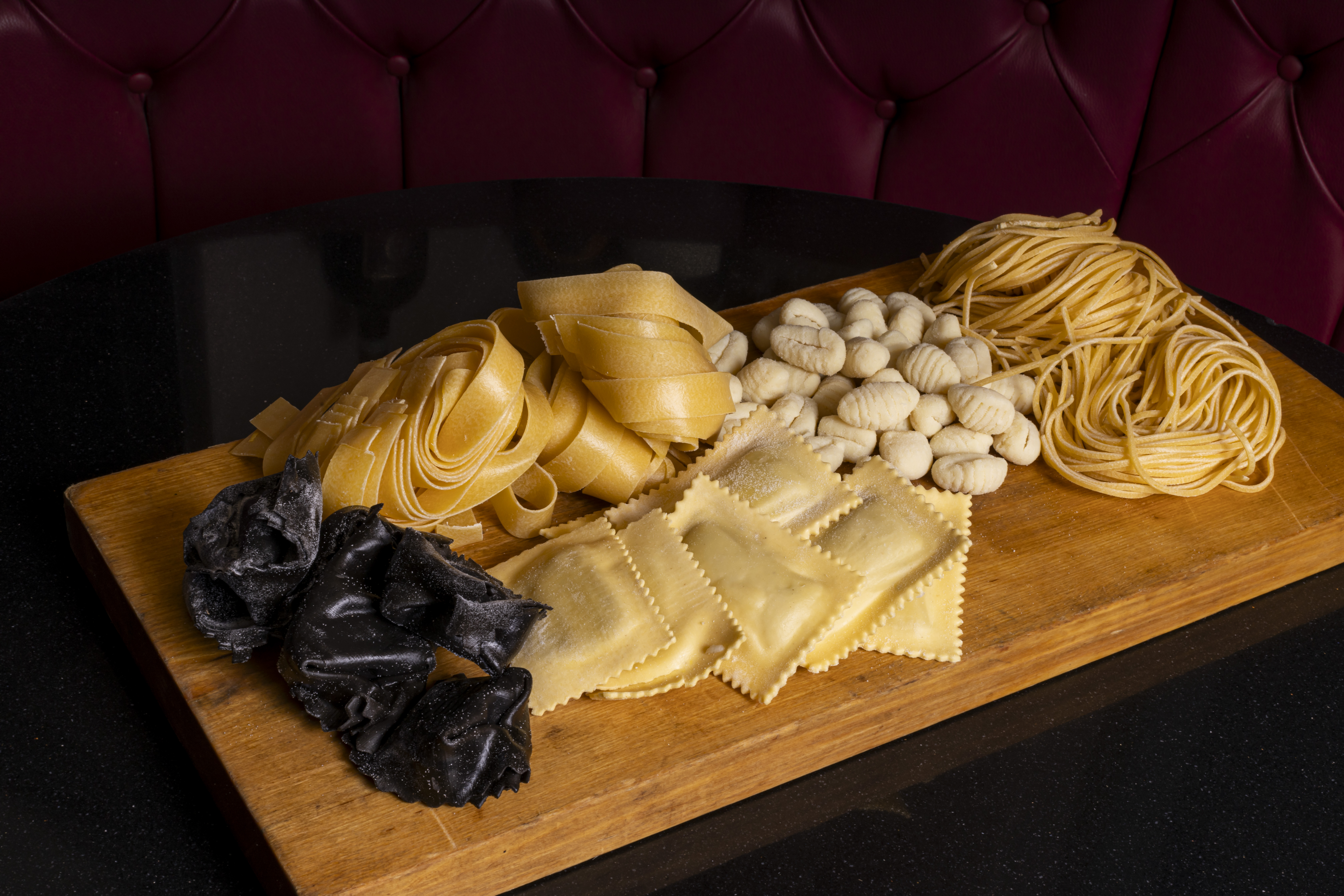 Ravioloni artigianali ripieni di zucca serviti con fonduta di taleggio e nocciole tostate