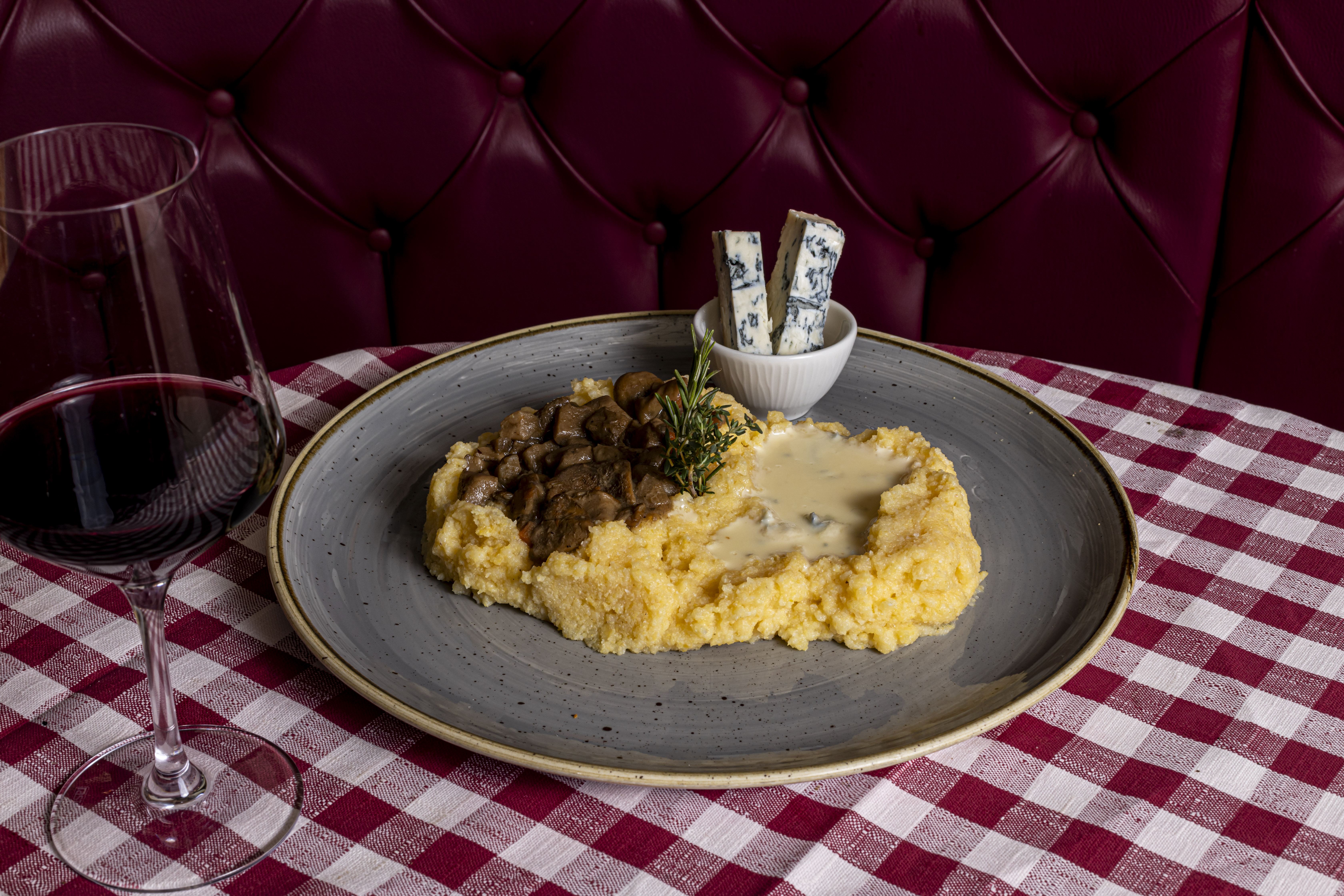 Polenta Taragna servita con fonduta di formaggio fuso, come da tradizione della Taverna del Borgo Antico