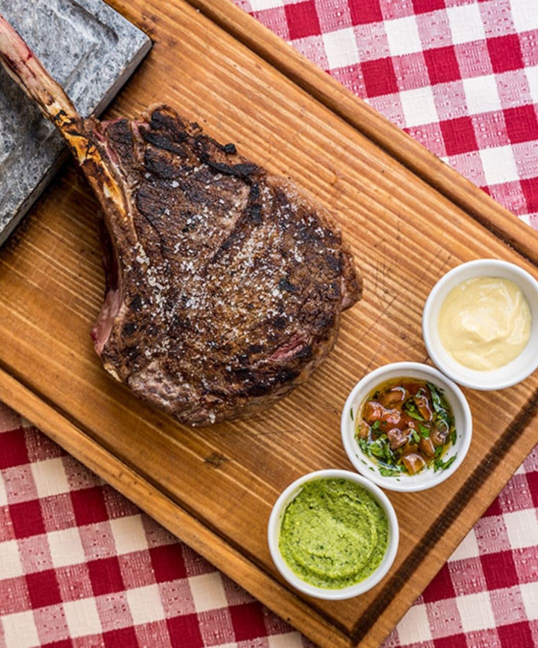 Tomahawk alla griglia servita su tagliere con salse alla Taverna del Borgo Antico, osteria a Brera